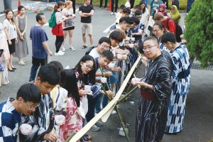 国際交流会で流しそうめんを楽しむ参加者達