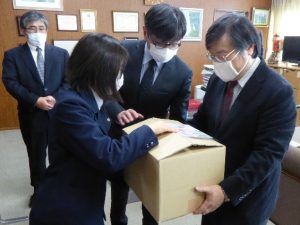 島田学長（右）に手作りマスクを渡す滝本さん（左）