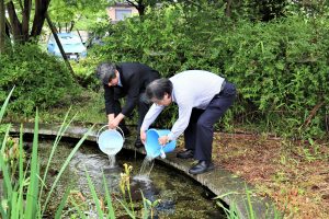 メダカを放流する島田特別顧問と木内病院長